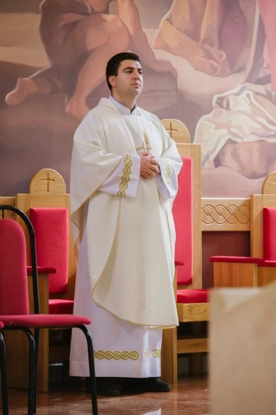 A man and a woman are reviewing documents with another man in a modern office space.